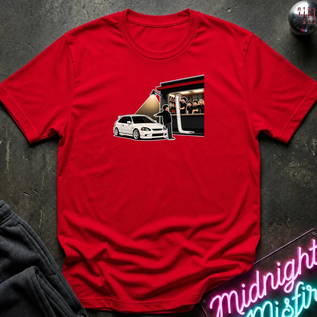 A red short-sleeve crewneck t-shirt laid flat on a dark textured surface. The shirt features a graphic print 
