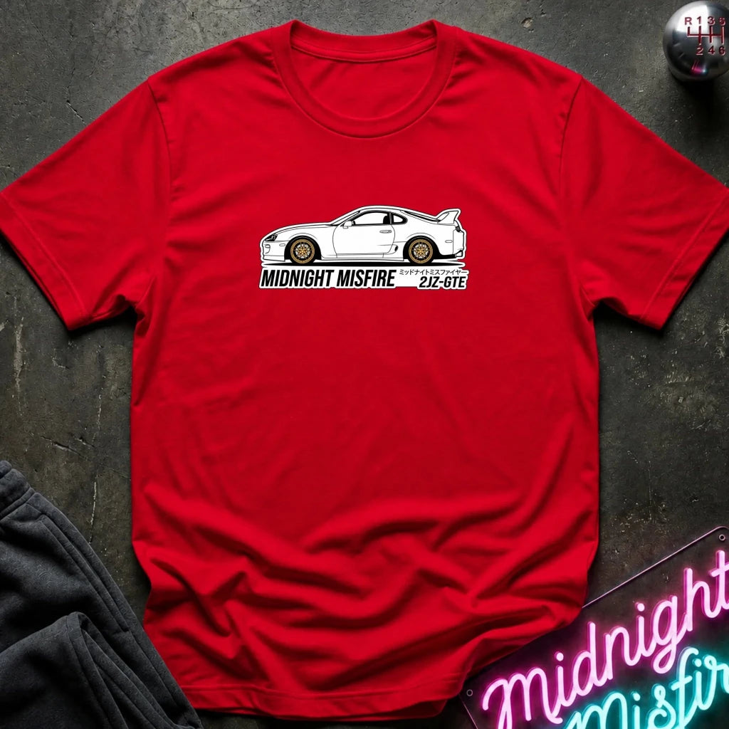 red short-sleeve t-shirt laid flat on a dark textured surface, featuring a white sports car graphic and the text 'MIDNIGHT MISFIRE '