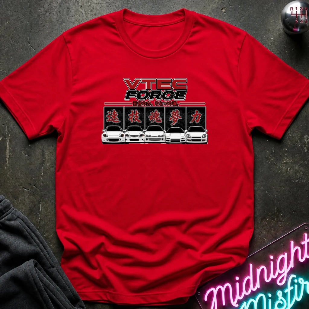 A red short-sleeve crewneck t-shirt featuring a 'VTEC FORCE' car graphic on the chest, laid flat on a dark textured surface with a gear and neon sign in the background.