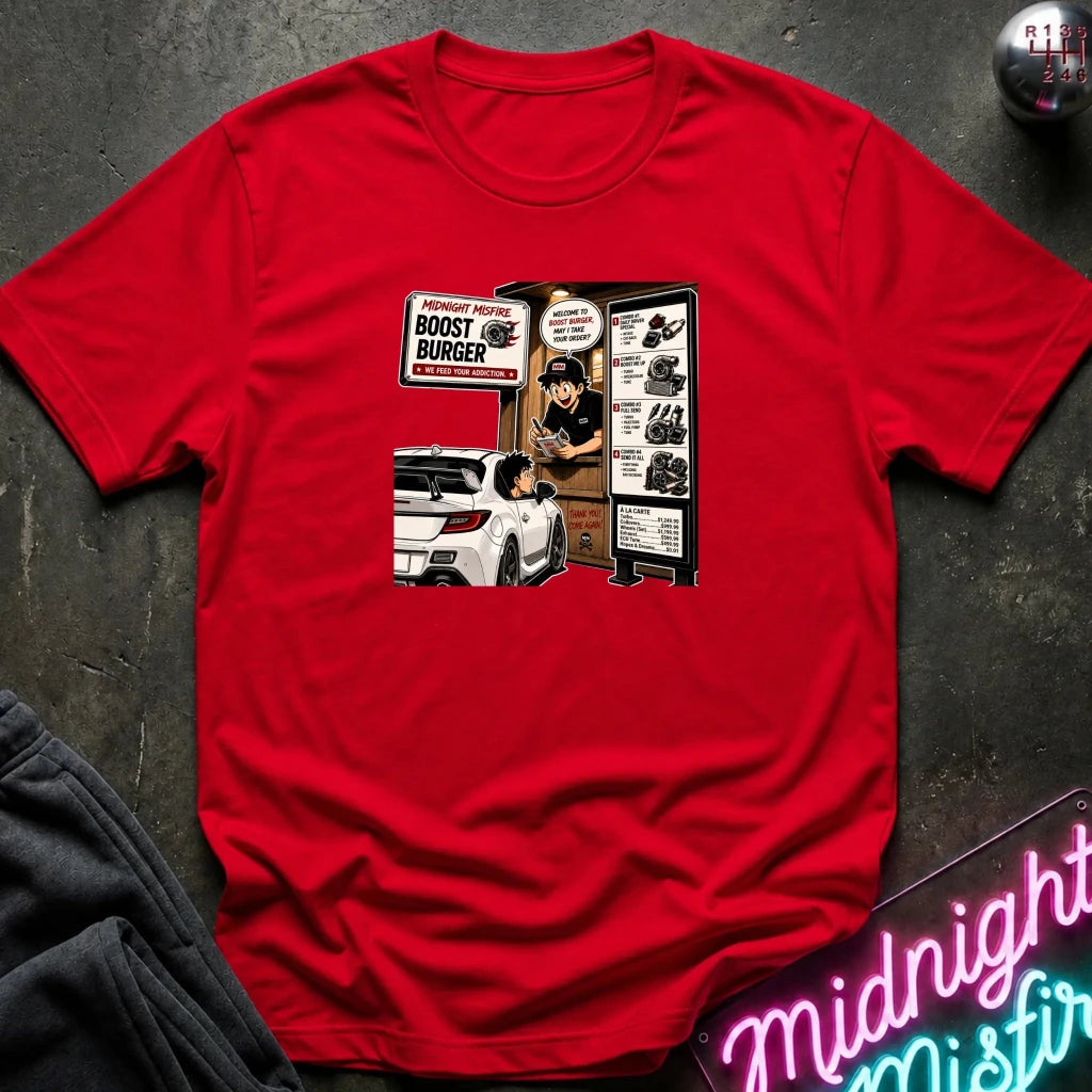 A red short-sleeve crewneck t-shirt laid flat on a dark textured surface, featuring a vintage-style comic book graphic of a burger stand with a white car and the words 'BOOST BUNGER'.