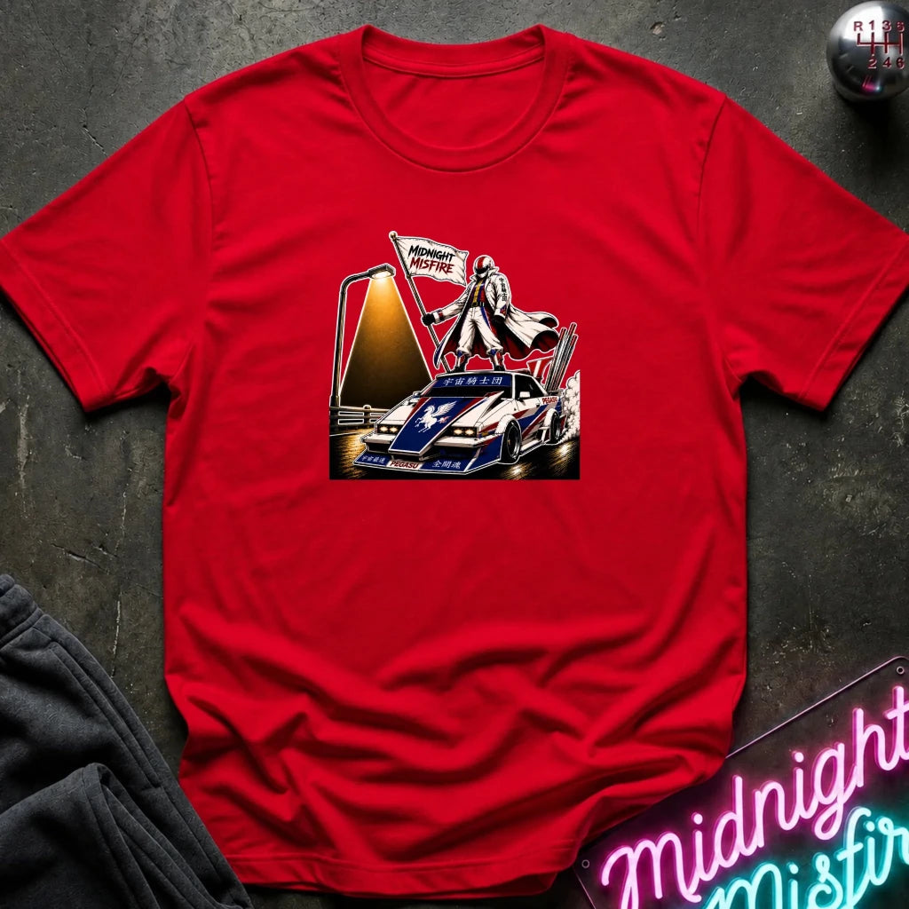 A red short-sleeve t-shirt laid flat on a dark textured surface, featuring a detailed graphic print of a vintage race car with a driver and a 'Midnite Misfire' flag. 