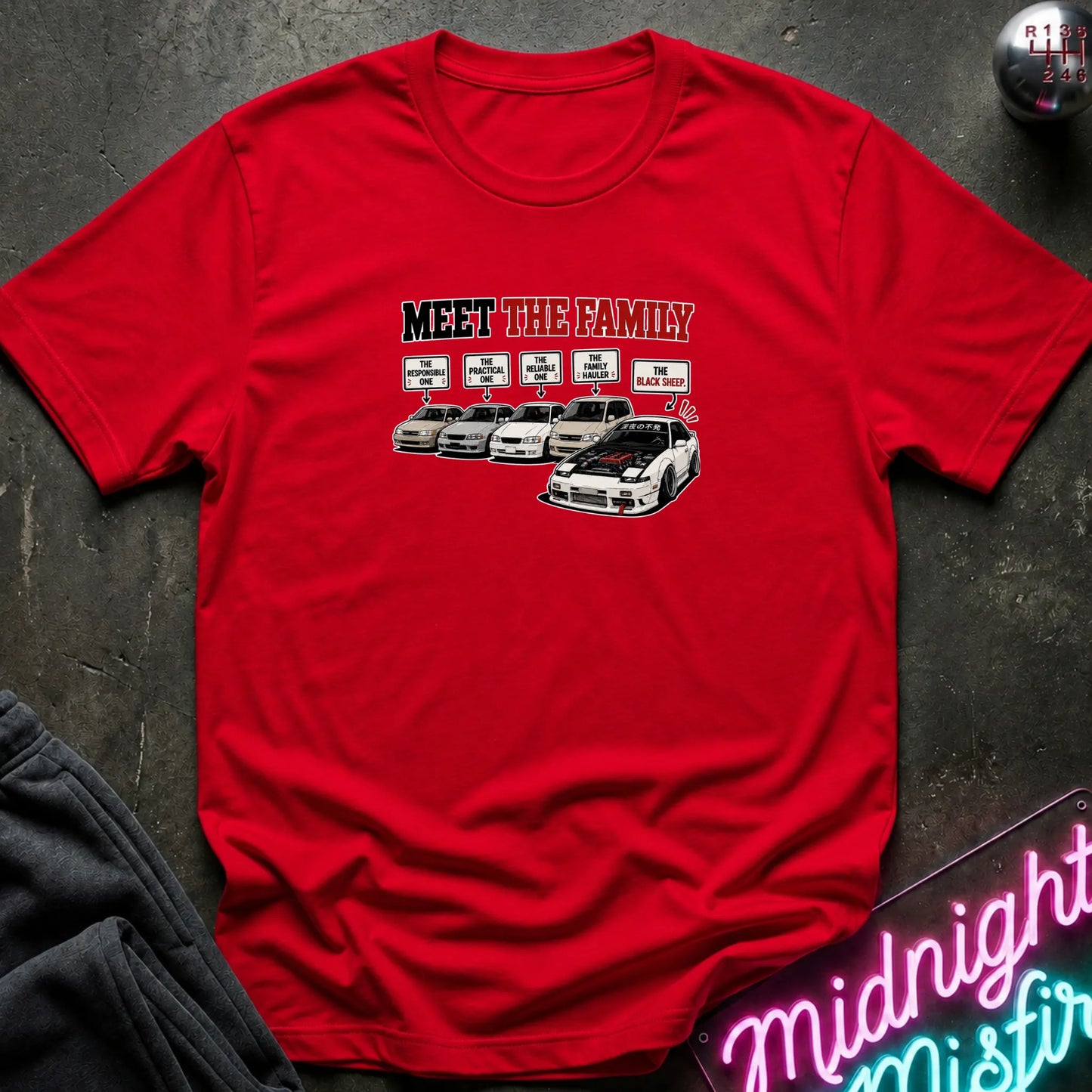 A red short-sleeved t-shirt  that has a cars parked with one standing out that says black sheep.