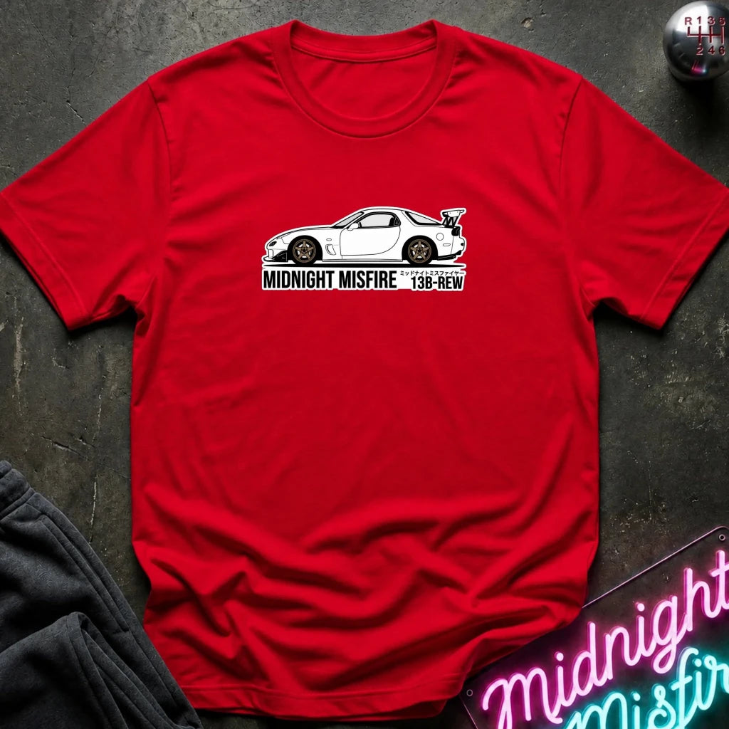 red short-sleeve t-shirt laid flat on a dark textured surface, featuring a white sports car graphic and the text 'MIDNIGHT MISFIRE '