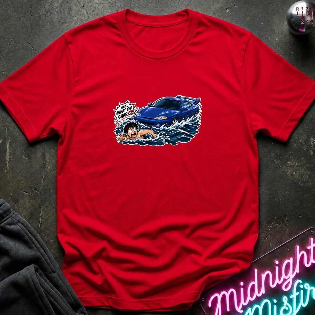 A red short-sleeved t-shirt that has a blue car chasing a swimmer in open water.