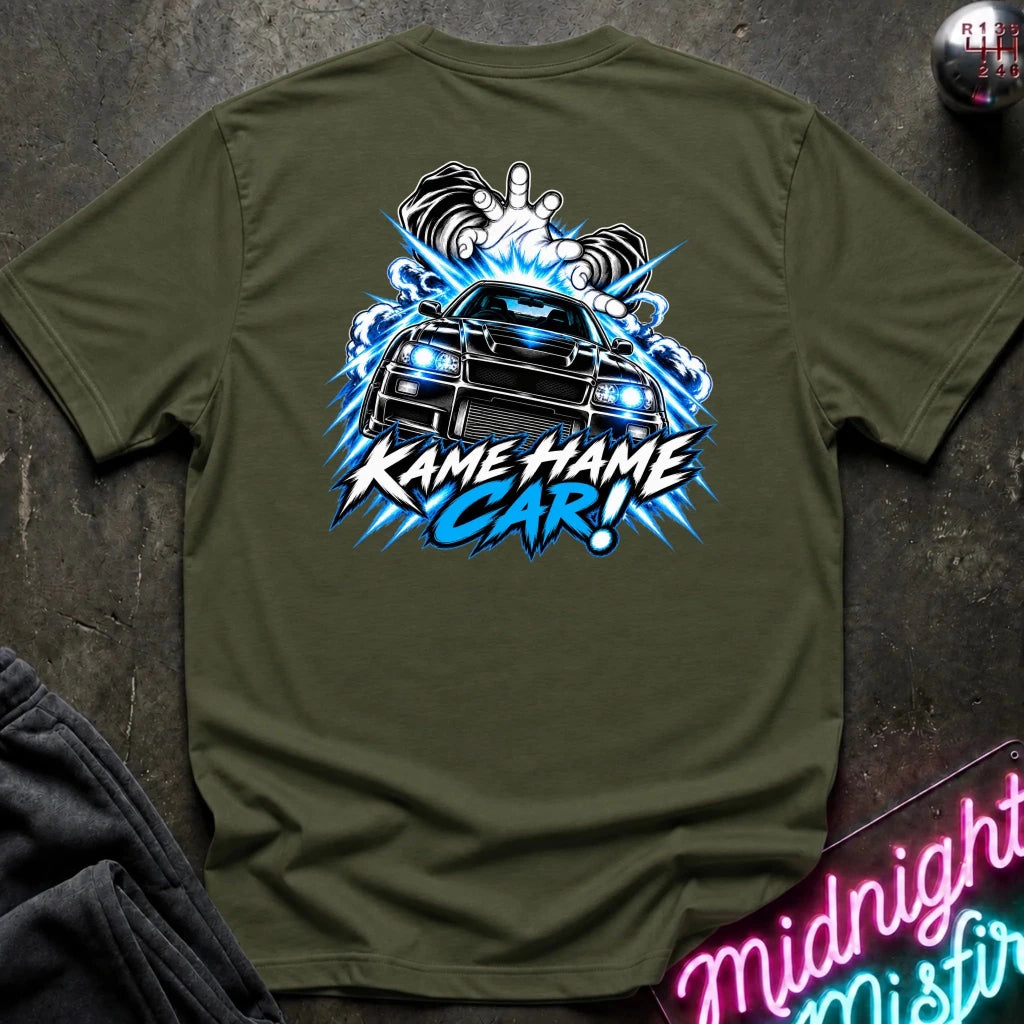 An olive green short-sleeve t-shirt laid flat on a dark textured surface, featuring a large graphic print on the back of a black car with blue lightning effects and the text 'KAME HAME CAR!'.