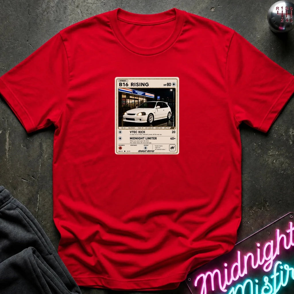 red crewneck t-shirt laid flat on a dark textured surface, featuring a graphic print of vintage card and a car.