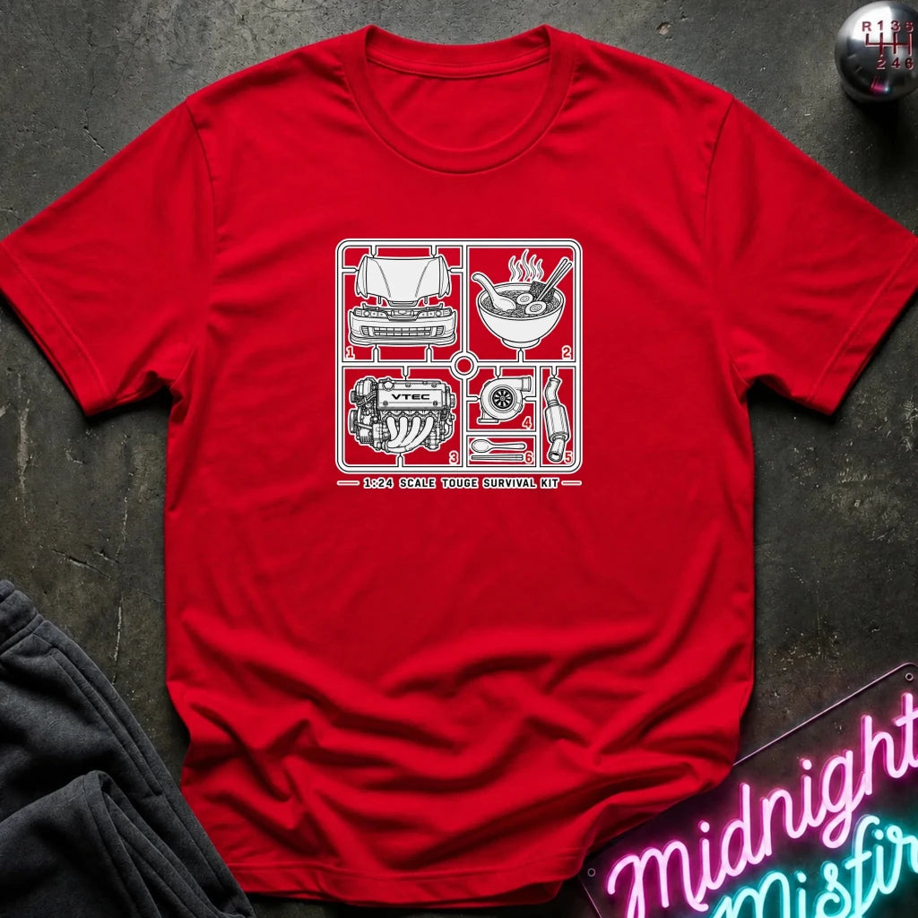 A red short-sleeve crewneck t-shirt laid flat on a dark textured surface, featuring a white graphic print of classic car parts and tools inside a grid,