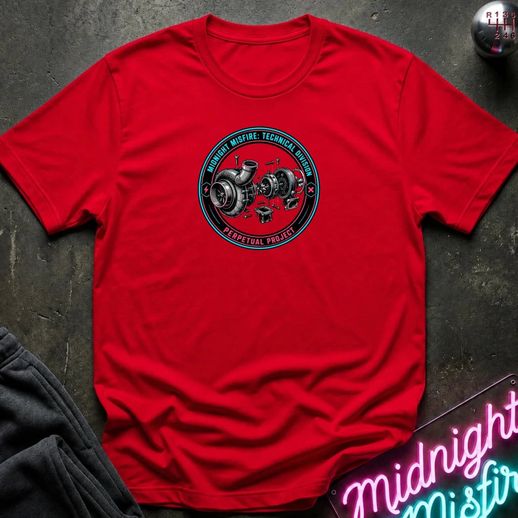 A red short-sleeve crewneck t-shirt laid flat on a dark textured surface, featuring a circular graphic in the center with a turbocharger illustration 