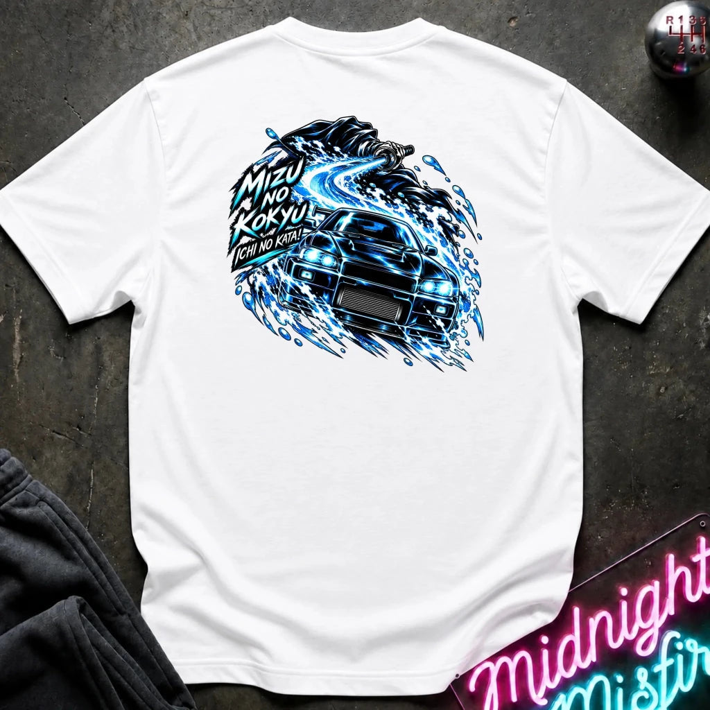 A white short-sleeve t-shirt laid flat on a dark textured surface, featuring a large back graphic of a black sports car surrounded by blue electric swirls and Japanese text. A neon sign and dark pants are partially visible as props.