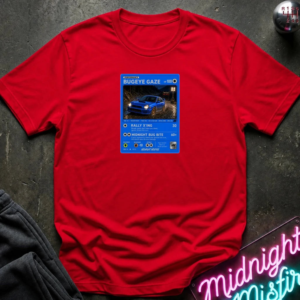 red crewneck t-shirt laid flat on a dark textured surface, featuring a graphic print of vintage card and a car.