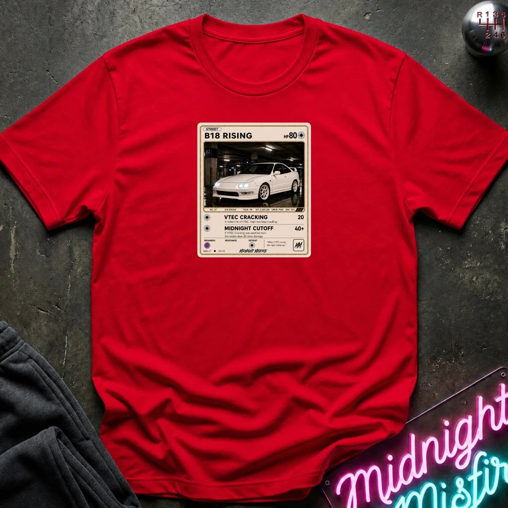 red crewneck t-shirt laid flat on a dark textured surface. The shirt features a graphic print styled like a retro card