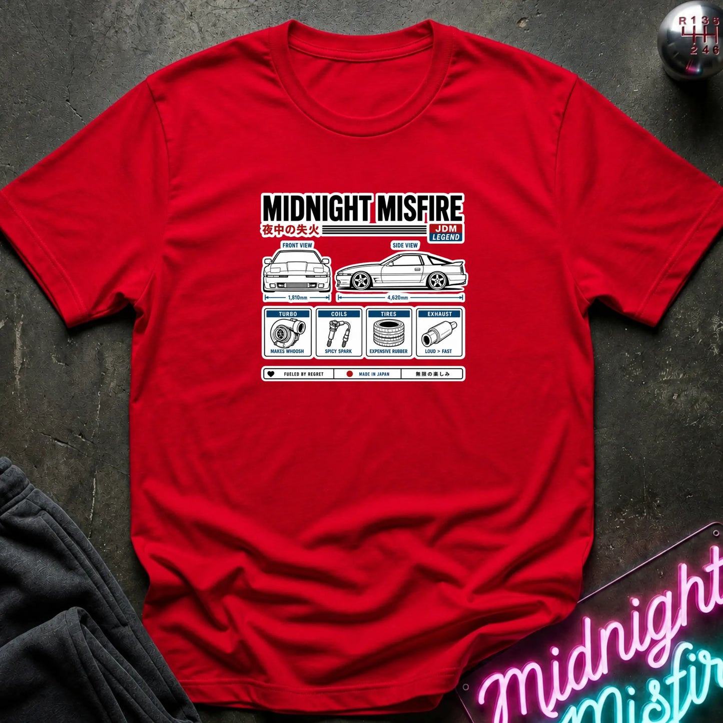 A red short-sleeve t-shirt laid flat on a dark textured surface, featuring a technical schematic graphic of car parts.