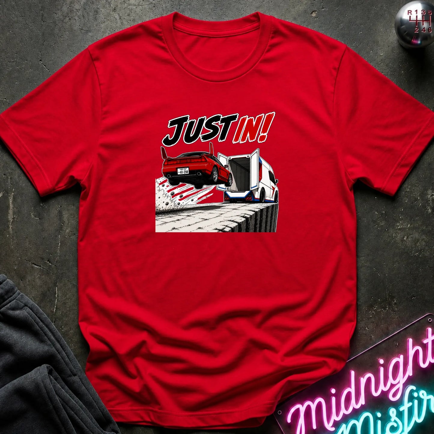 A red short-sleeved t-shirt  that has a red car jumping into back of another machine.