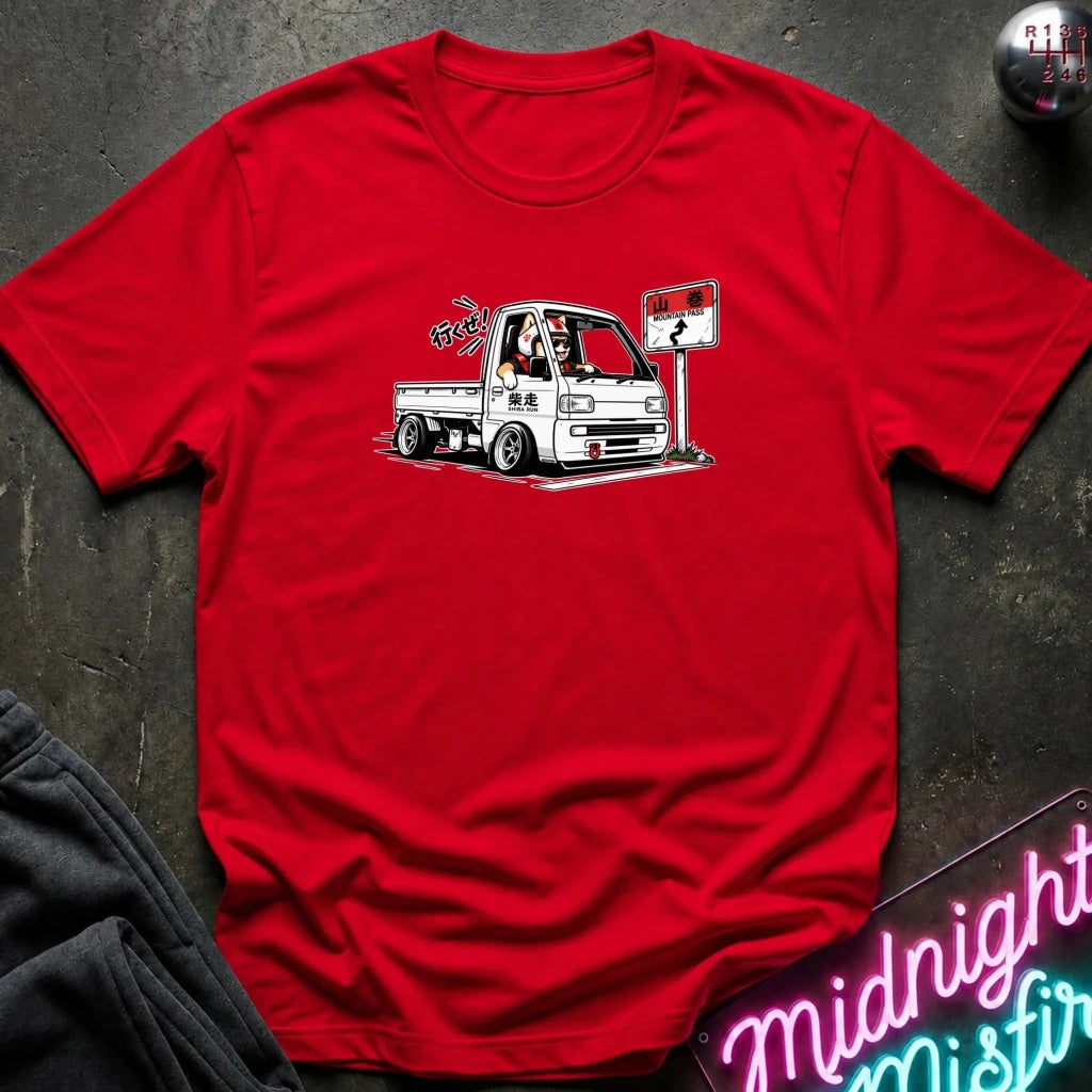 red short-sleeve crewneck t-shirt laid flat on a dark textured surface. The shirt features a graphic print of shiba inu dog.