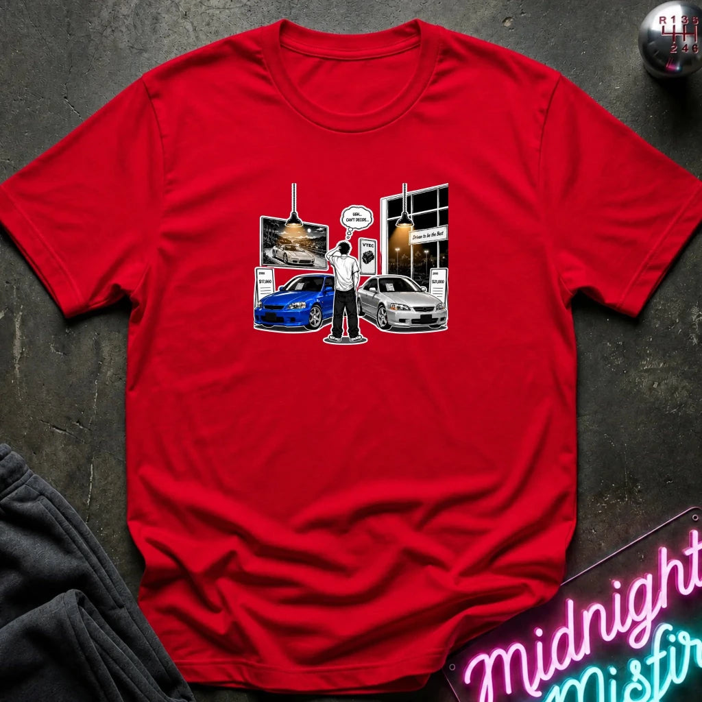 A red short-sleeve crewneck t-shirt laid flat on a dark textured surface. The center of the shirt features a graphic print depicting a scene with a blue and silver  sports cars