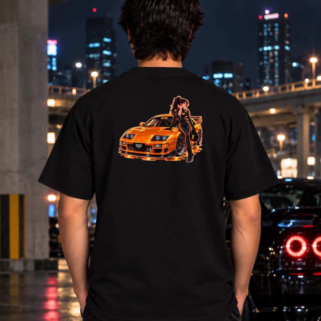 man wearing a black t-shit  featuring a large graphic print of an orange sports car with a woman in a black outfit on the back.