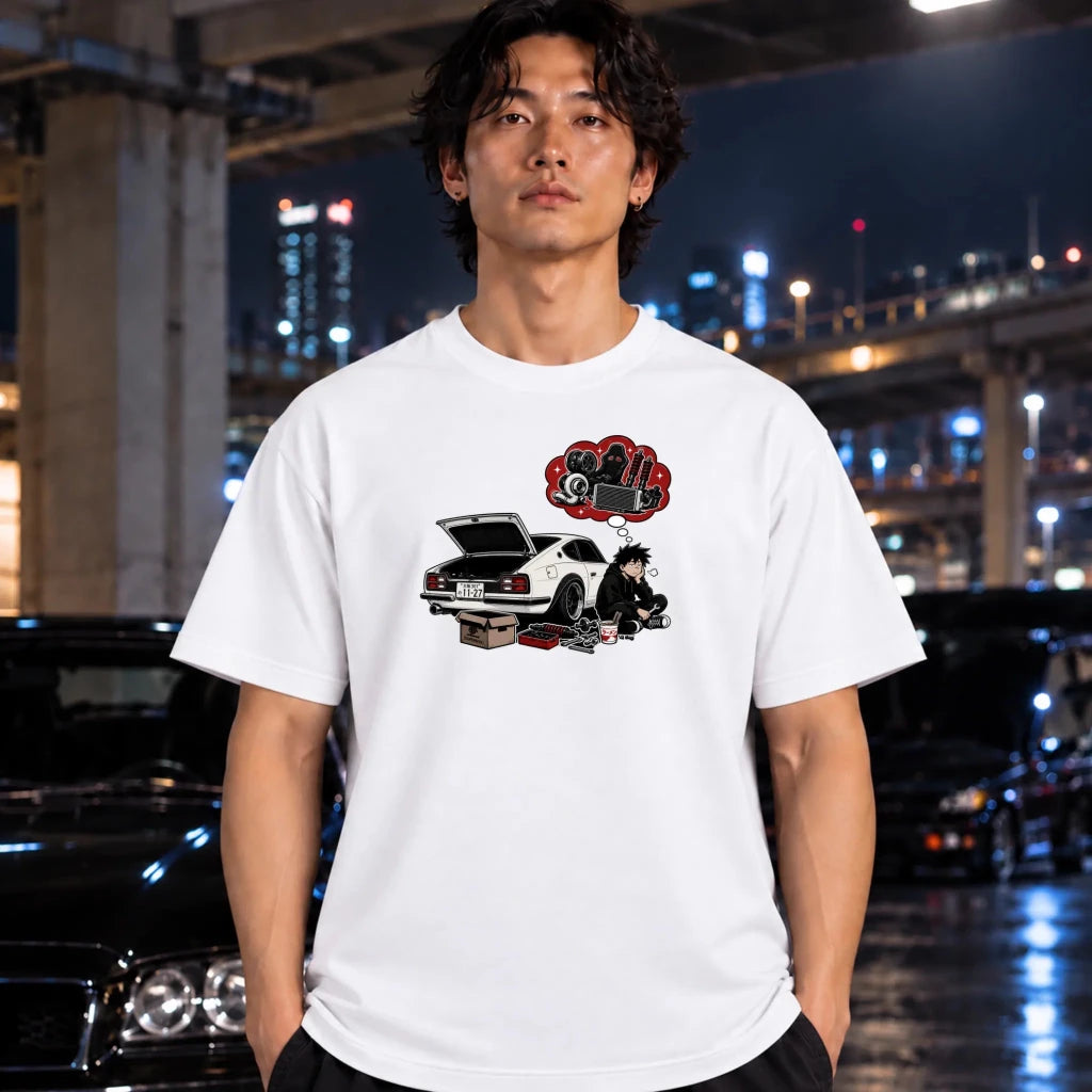 A man wearing a white graphic t-shirt with a car-themed print, standing in front of a blurred night city background with cars.
