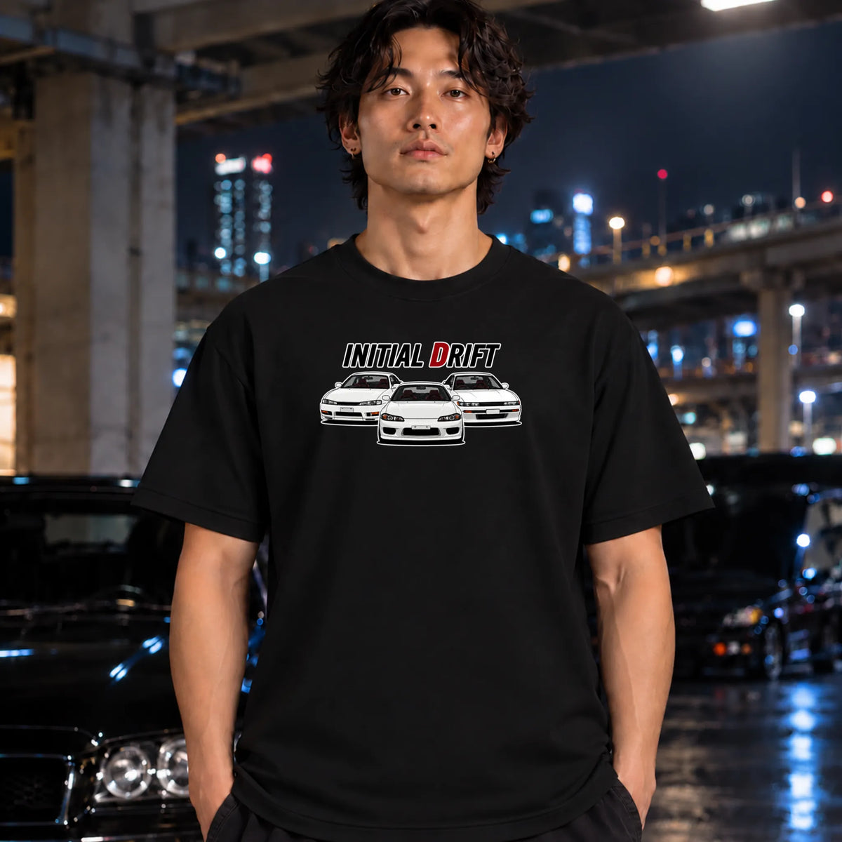 A black short-sleeve graphic t-shirt worn by a man. The shirt features a white and red graphic print that reads 'INITIAL DRIFT' above three white drift cars.