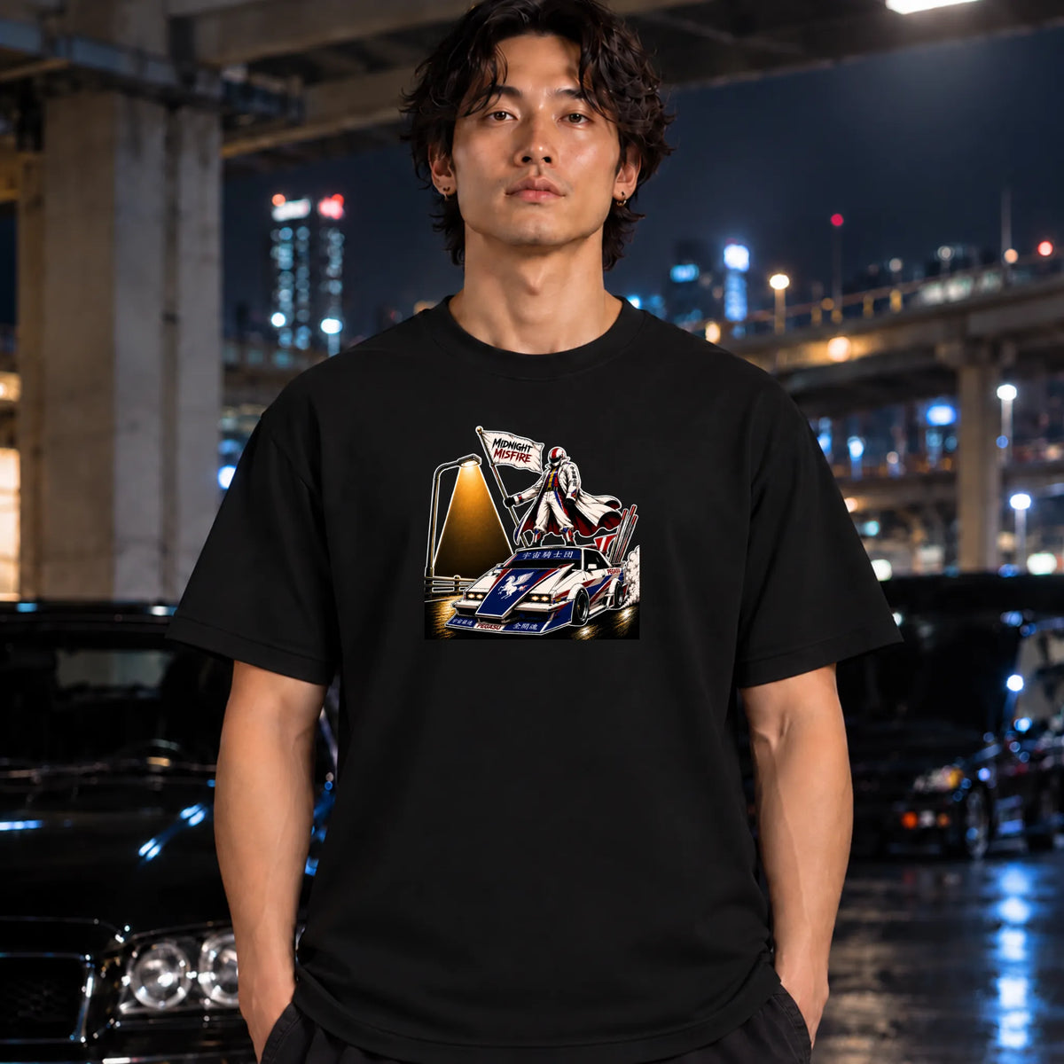 A black short-sleeve crewneck t-shirt featuring a graphic print of a vintage race car with a driver and a large screen, worn by a man