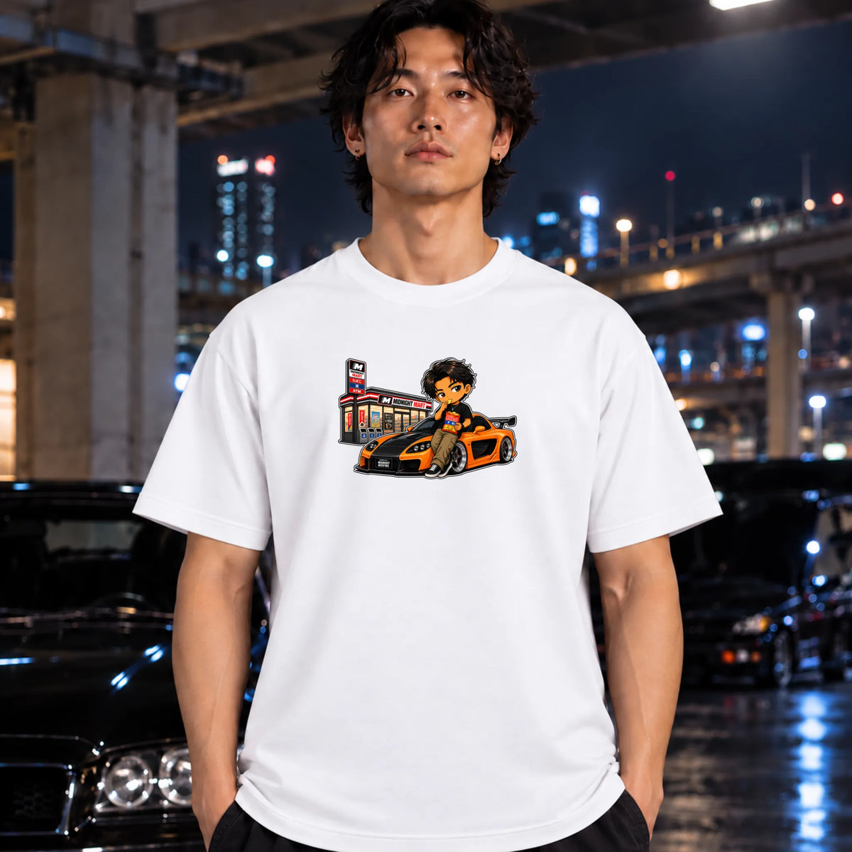 man wearing a white t-shirt featuring a cartoon graphic of a man sitting on a orange and black sports car next to a store.