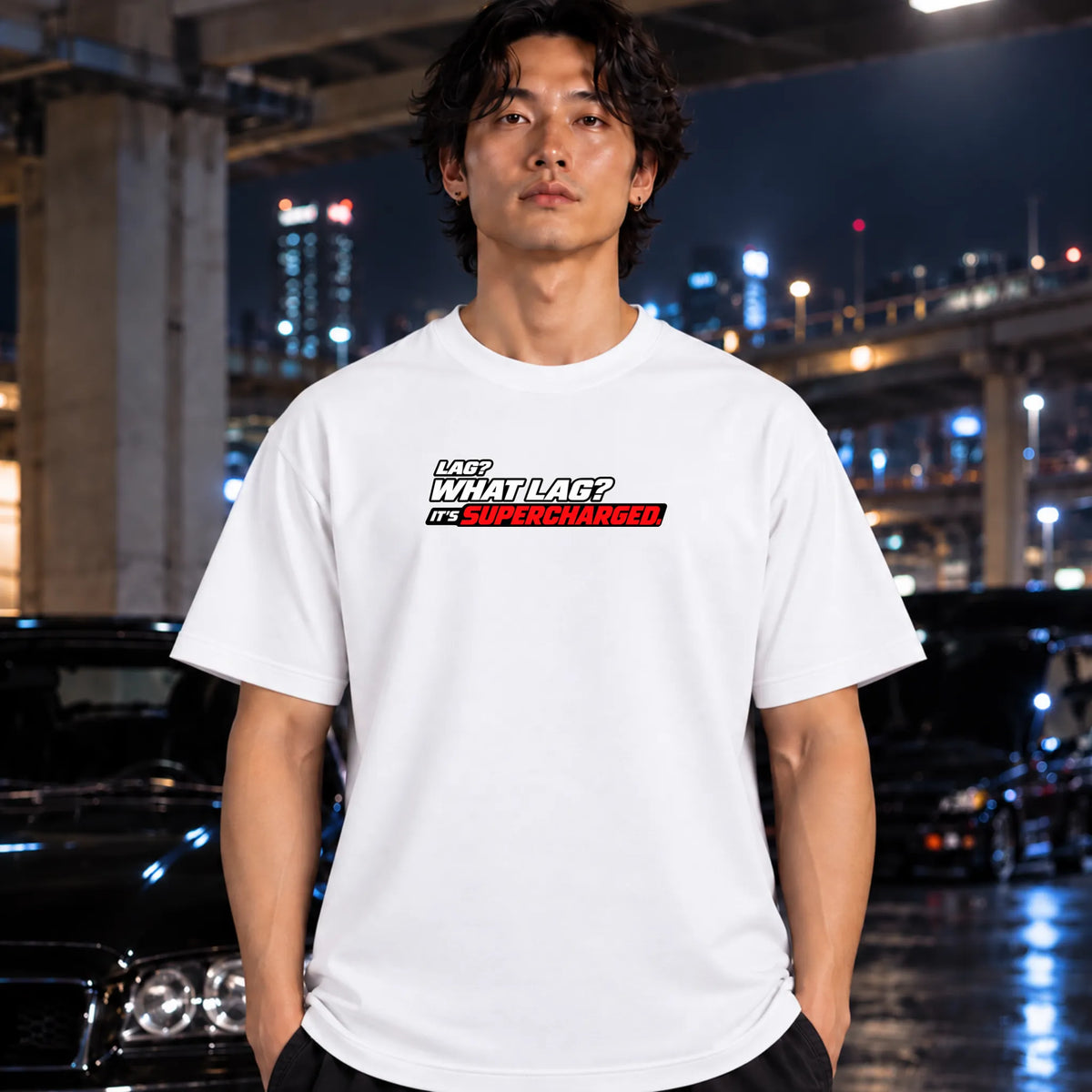 black short-sleeve t-shirt worn by a man with a graphic text print reading 'LAG? WHAT LAG? IT'S SUPERCHARGED' in white, black, and red. 